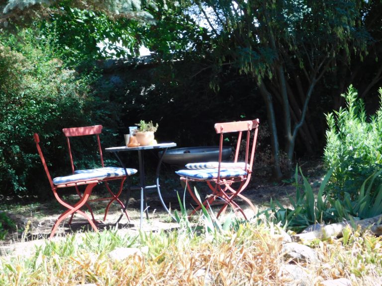 Tisch mit roten Stühlen im Garten